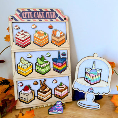 wooden display with cake and dollop enamel pins from cute cake club by carly k of mythic mgmt